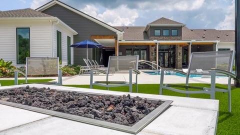 A modern house with a pool and a fire pit in the backyard.