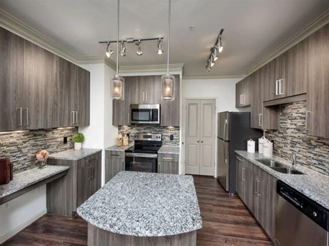 a kitchen with granite counter tops and stainless steel appliances