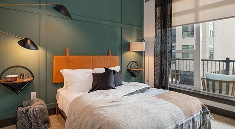 a bedroom with a bed and a large window