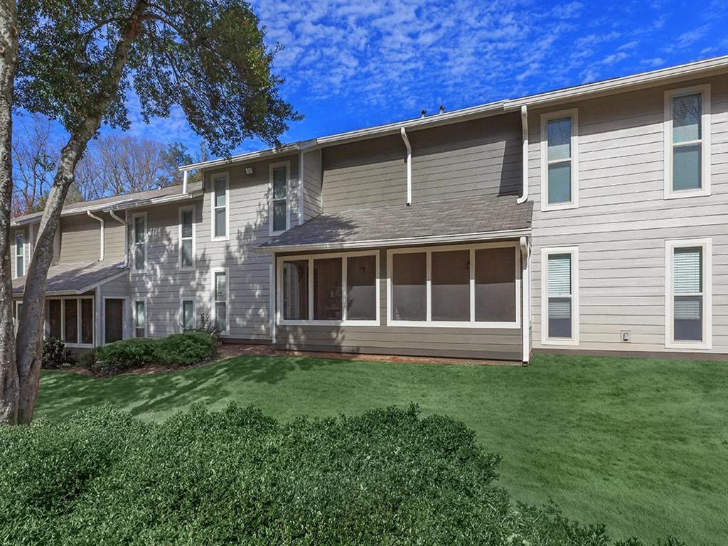 a gray apartment building with a green lawn at The Ellis Apartments, Clarkston