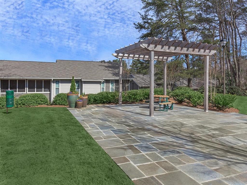 a patio with a pergola in front of a house at The Ellis Apartments, Clarkston, 30021