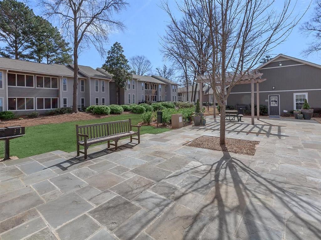 a park with benches and trees and buildings in the background at The Ellis Apartments, Clarkston, GA