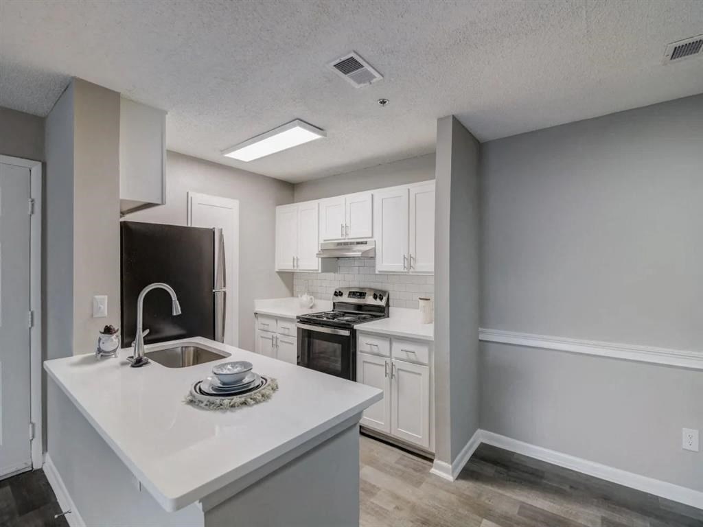 a white kitchen with a sink and a refrigerator at The Sapphire, Decatur