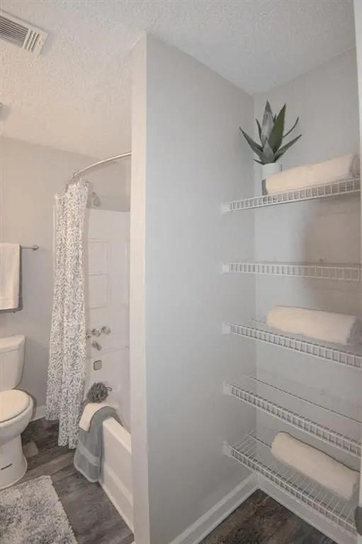 a white bathroom with a shower and a toilet at The Sapphire, Decatur, 30035