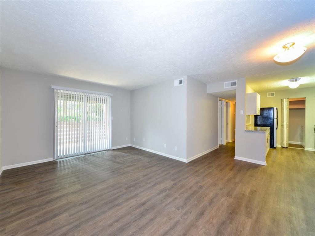 the living room and dining room of an empty house with wood floors