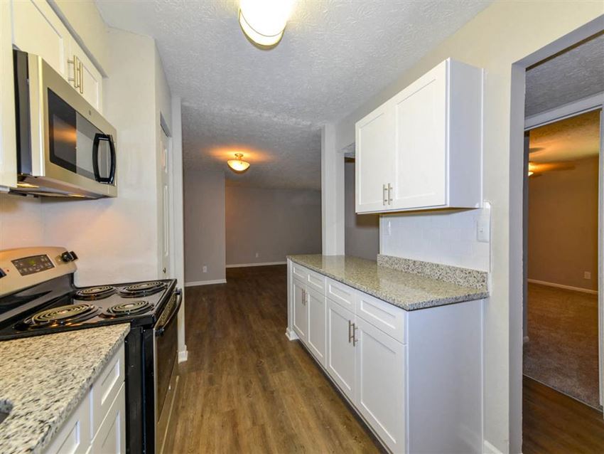 a kitchen with white cabinets and a stove and microwave