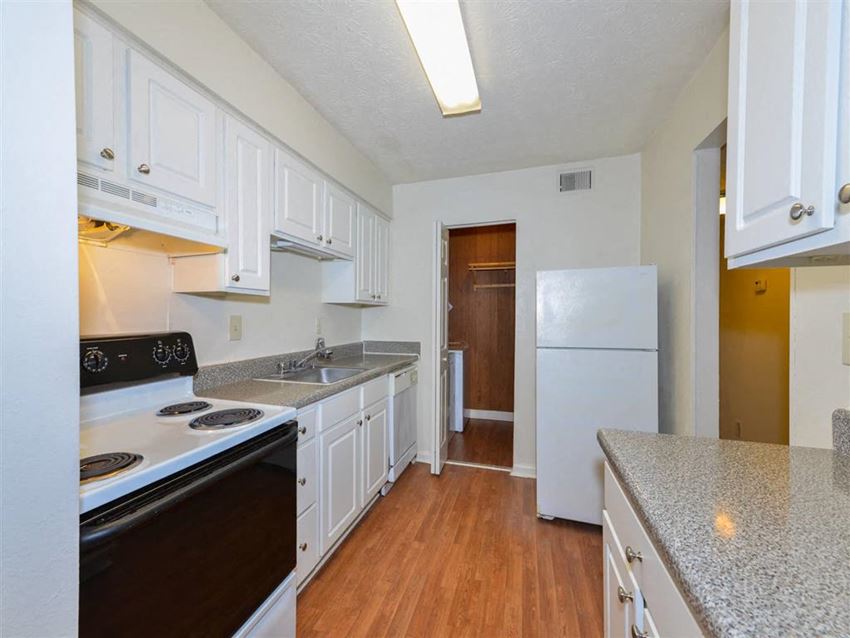 a kitchen with white cabinets and a white refrigerator