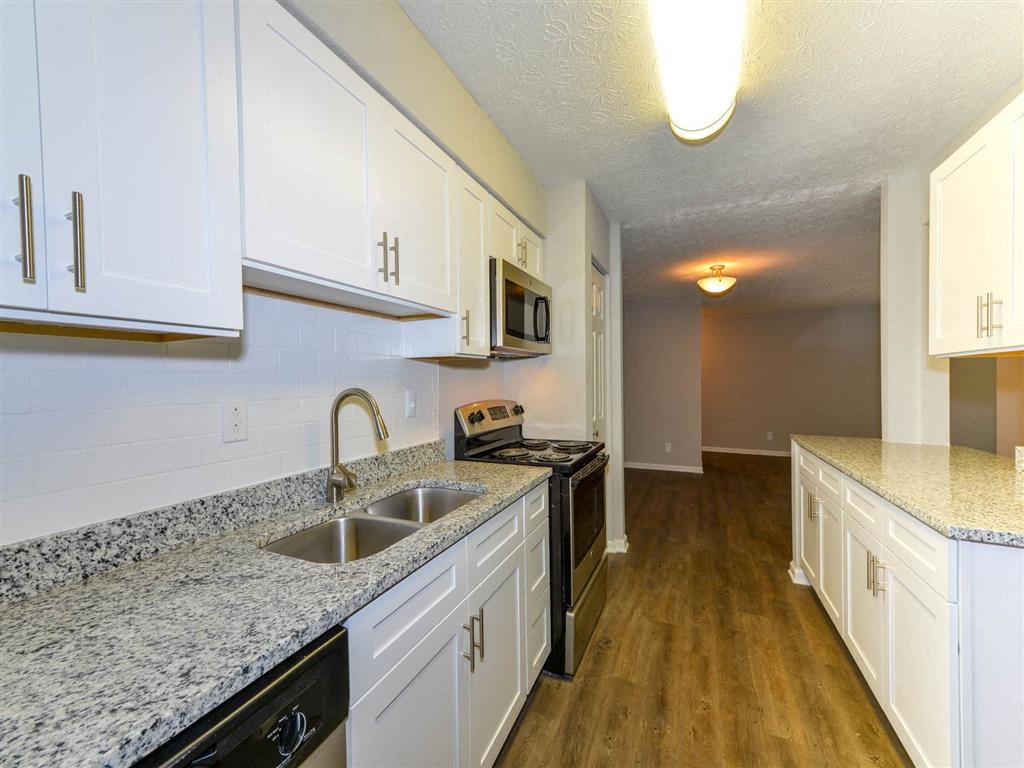 a kitchen with white cabinets and granite counter tops