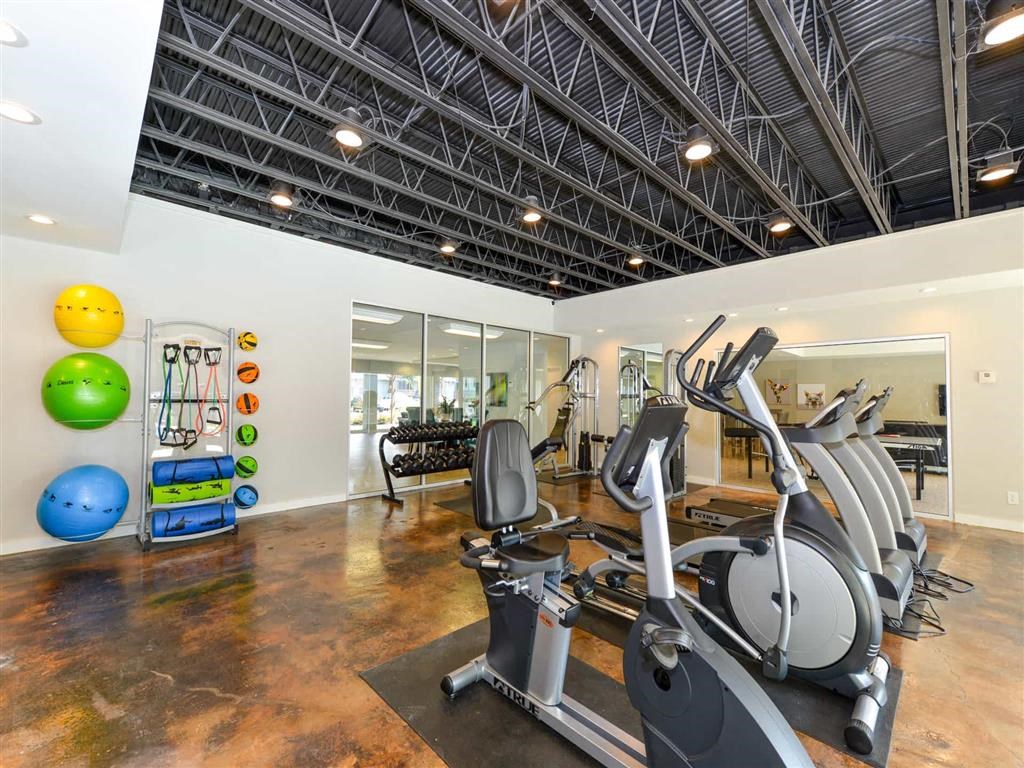 a gym with cardio equipment and weights in a fitness center