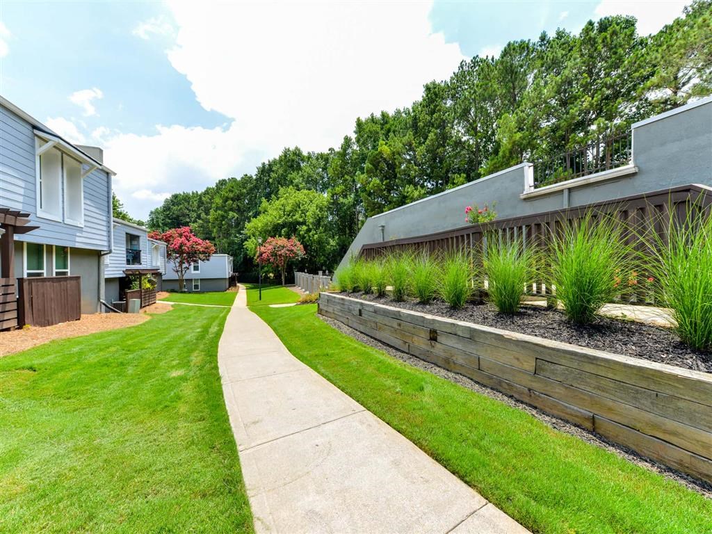 a yard with a sidewalk and some houses