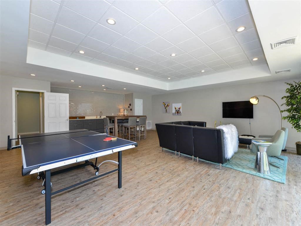 a game room with a ping pong table and a tv