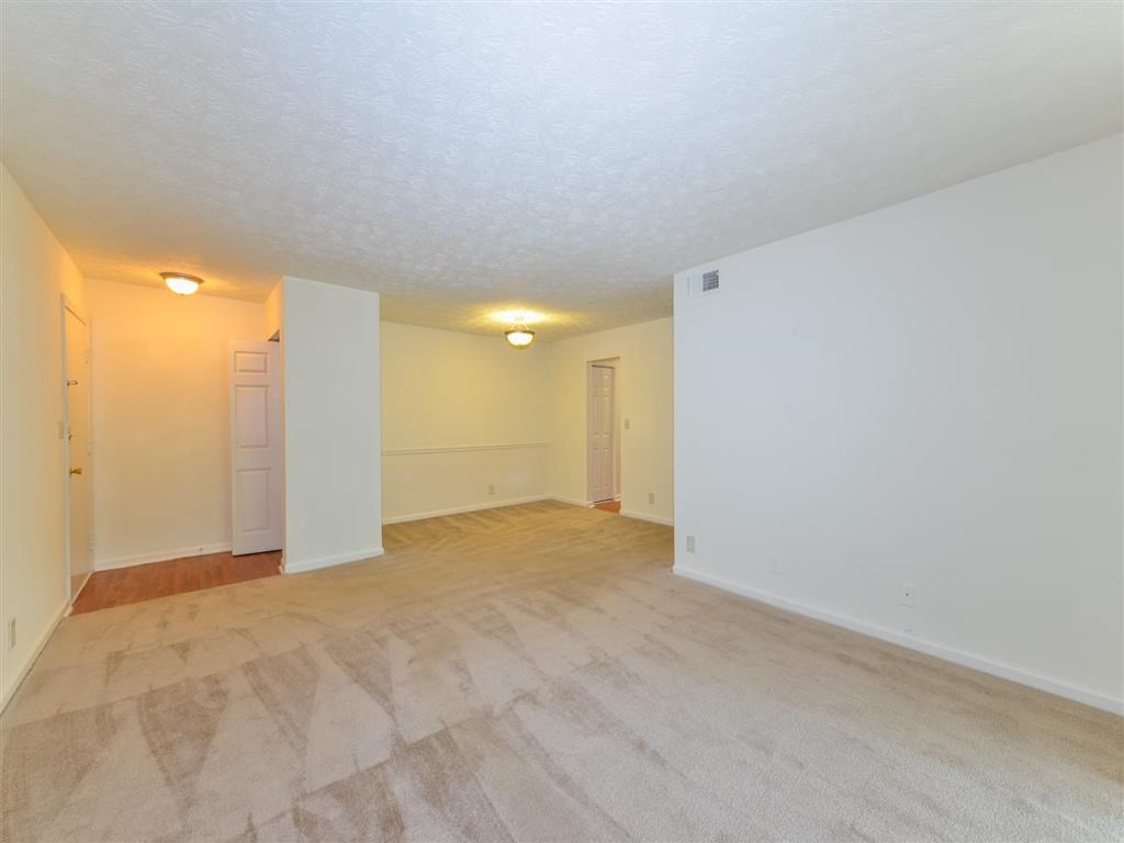 the living room and dining room of an empty apartment