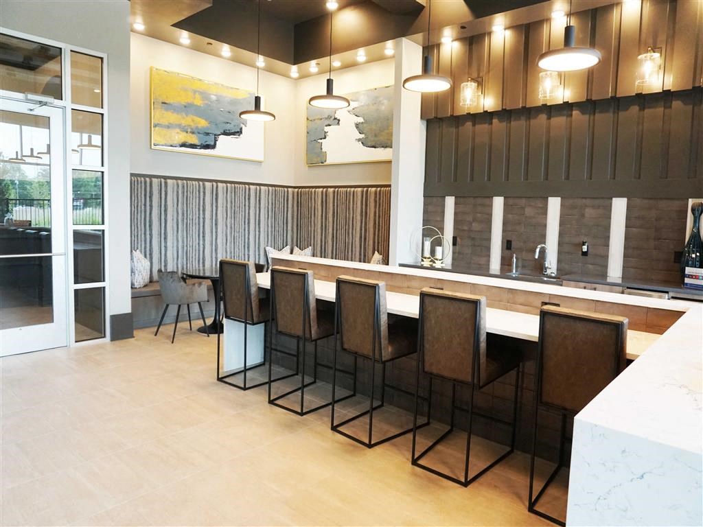 a kitchen with a bar and chairs in a lobby