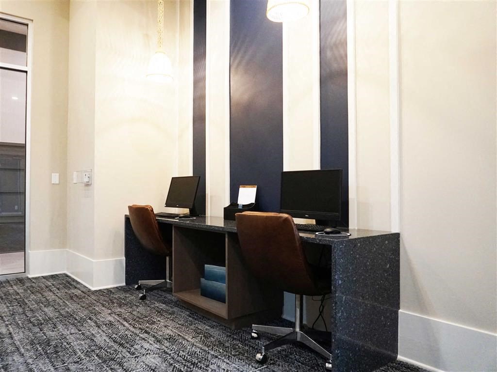 a desk with two computers and chairs in a room