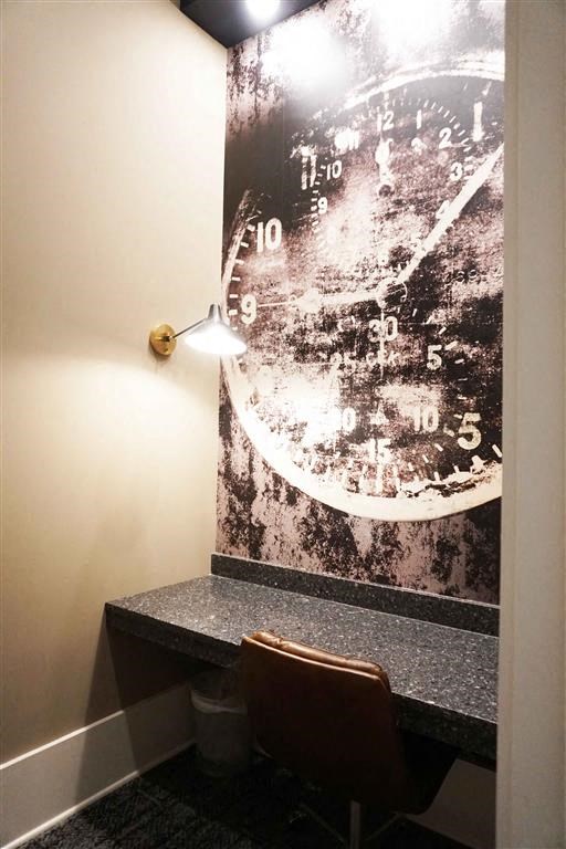 a clock on a wall in a room with a chair