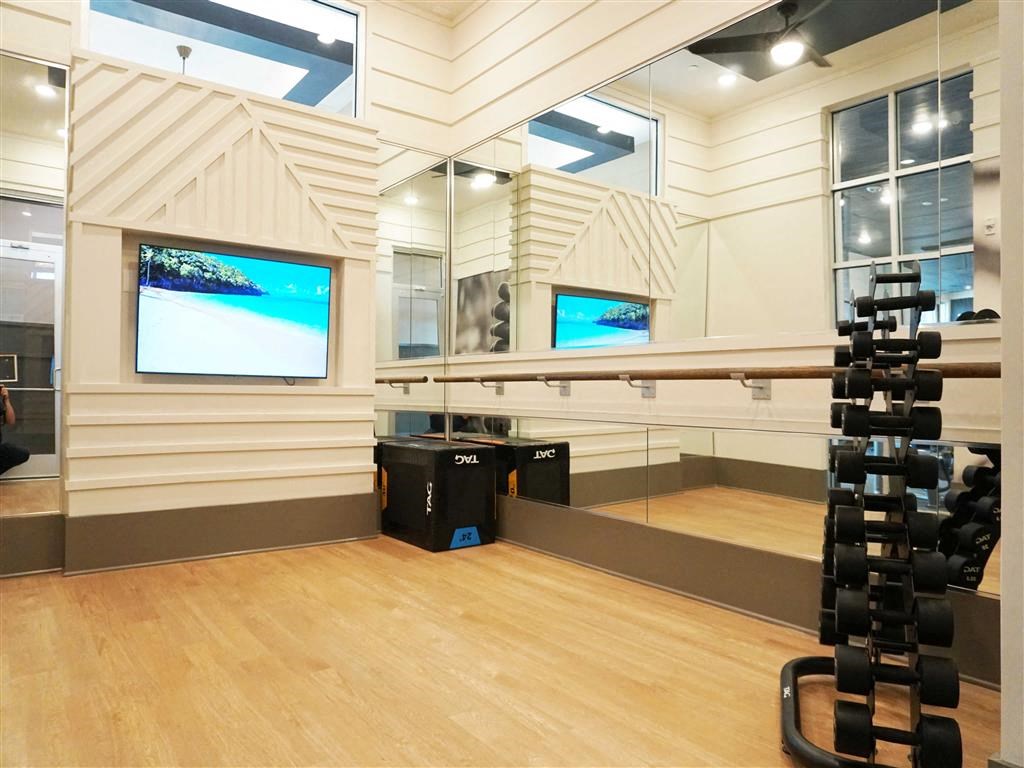 a home gym with a wooden floor and mirrored walls
