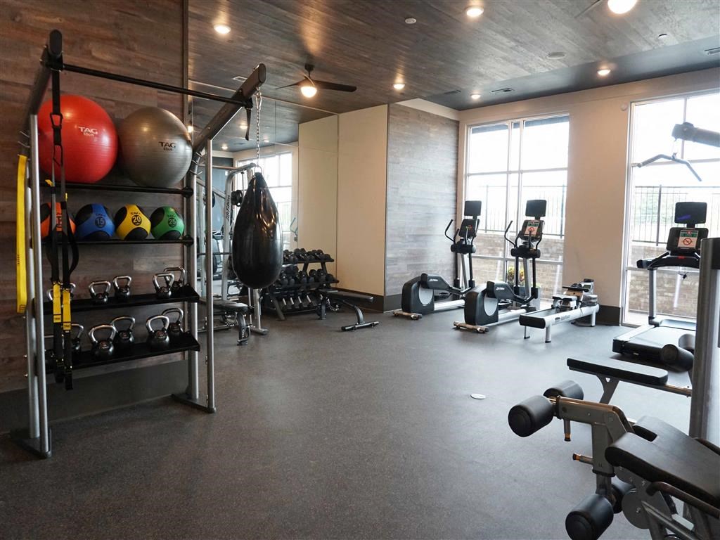 a gym with weights and other equipment and windows