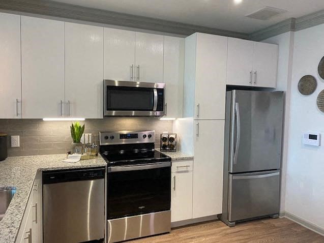 a kitchen with stainless steel appliances and white cabinets