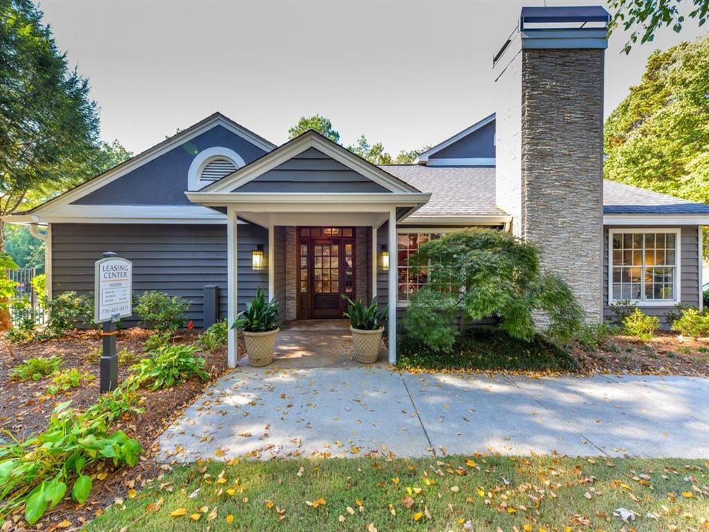 the front entrance of a house with a porch and a driveway