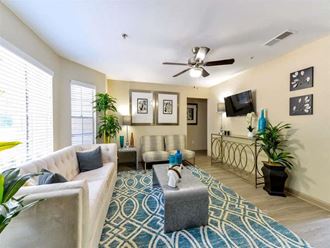 a living room filled with furniture and a ceiling fan