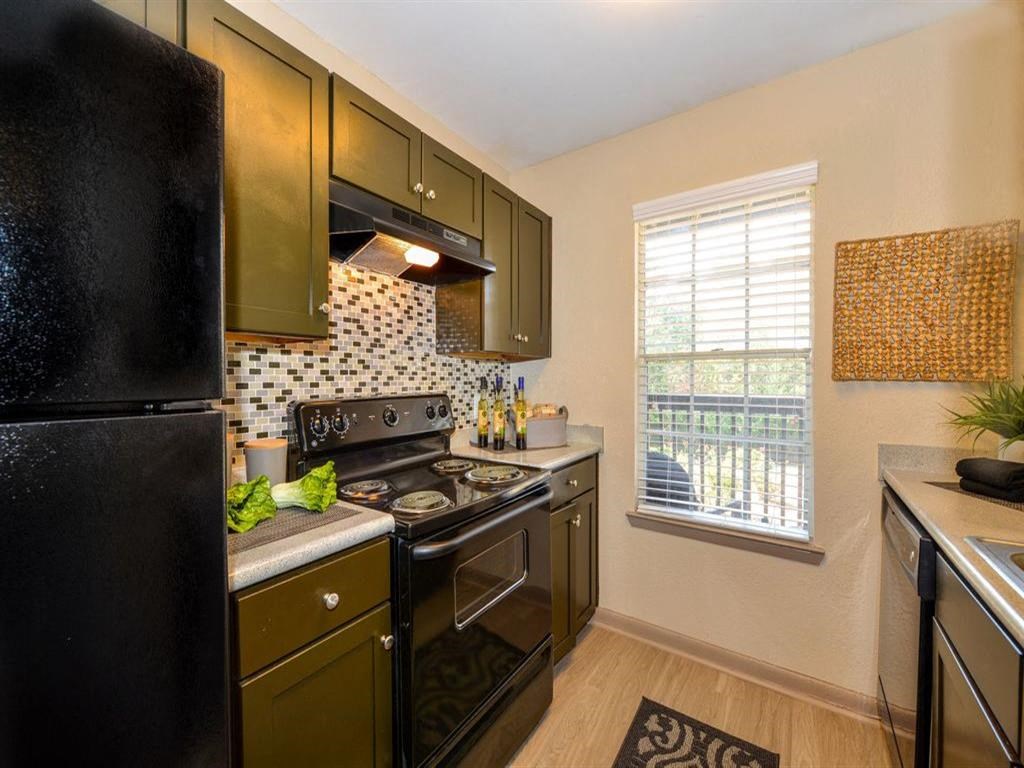 a kitchen with black appliances and a window