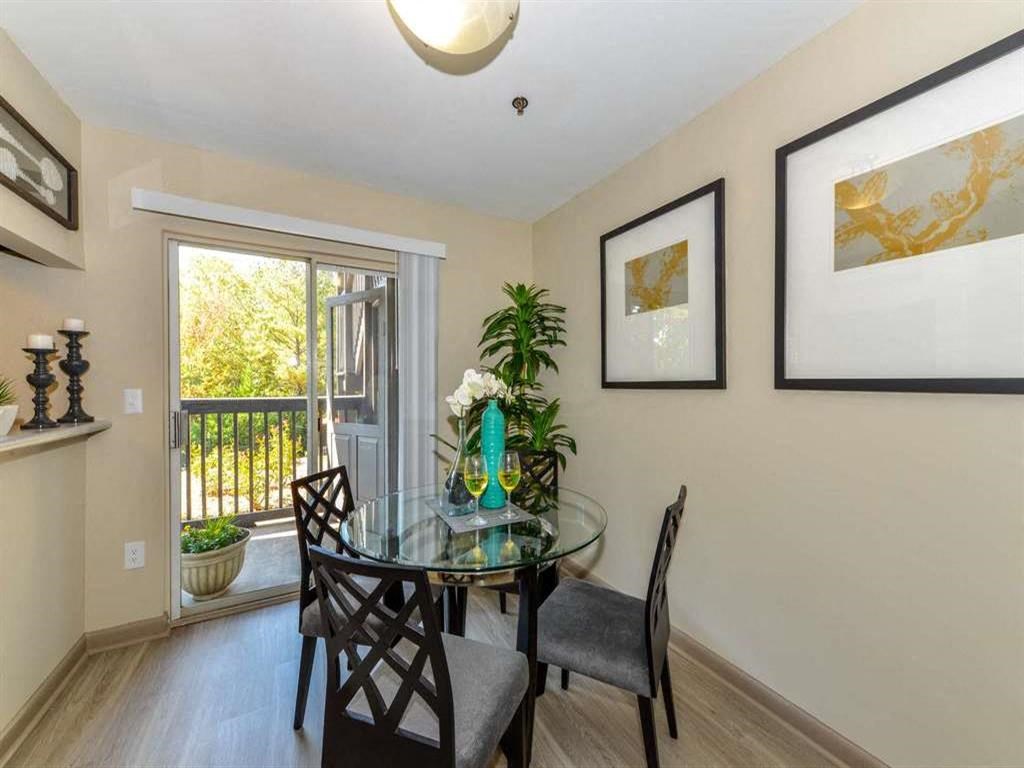 a dining room with a glass table and chairs and a window