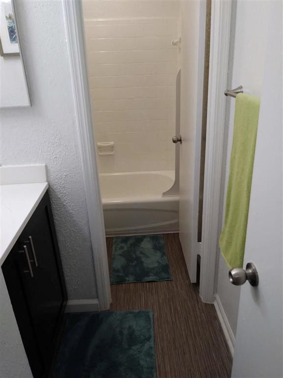a small bathroom with a shower and a green towel