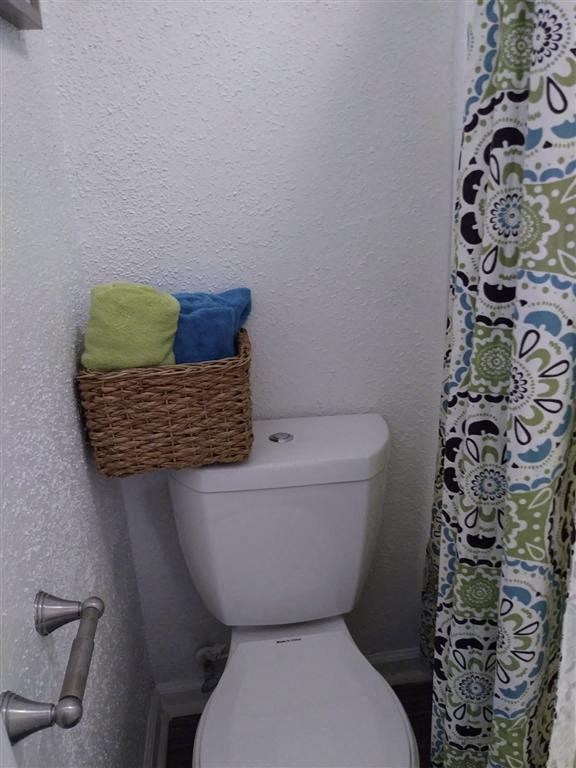 a bathroom with a toilet and a basket on top of it