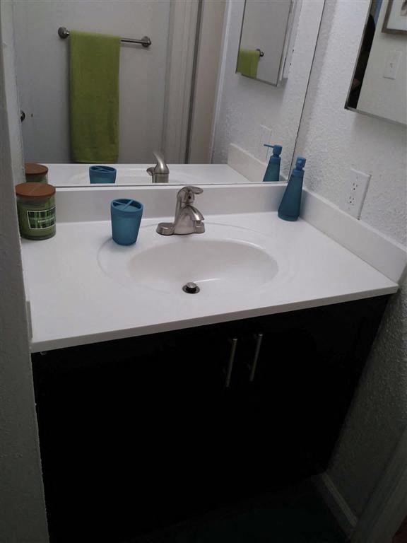 a bathroom with a white sink and a mirror