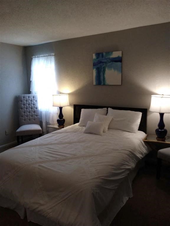 a bedroom with a bed and two lamps