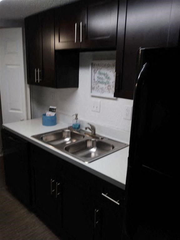 a kitchen with a sink and black cabinets