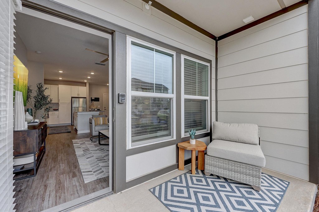 a living room with a couch and a door to a kitchen at Century Mundy Mill Apartments, Oakwood, GA 30566