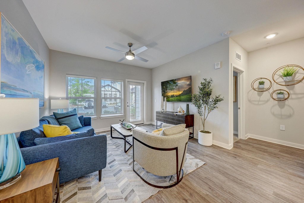 a living room with a couch and a chair and a ceiling fan at Century Mundy Mill Apartments, Oakwood
