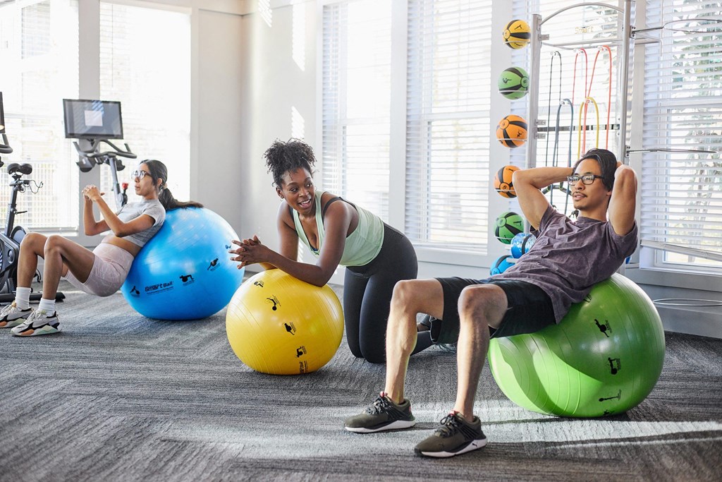 people working out on exercise balls in a gym at Century Mundy Mill Apartments, Oakwood, Georgia