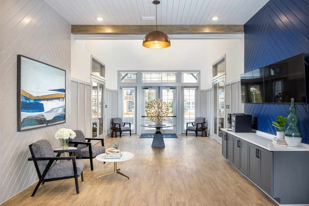 a living room with blue and white walls and a wood floor at Century Mundy Mill Apartments, Georgia