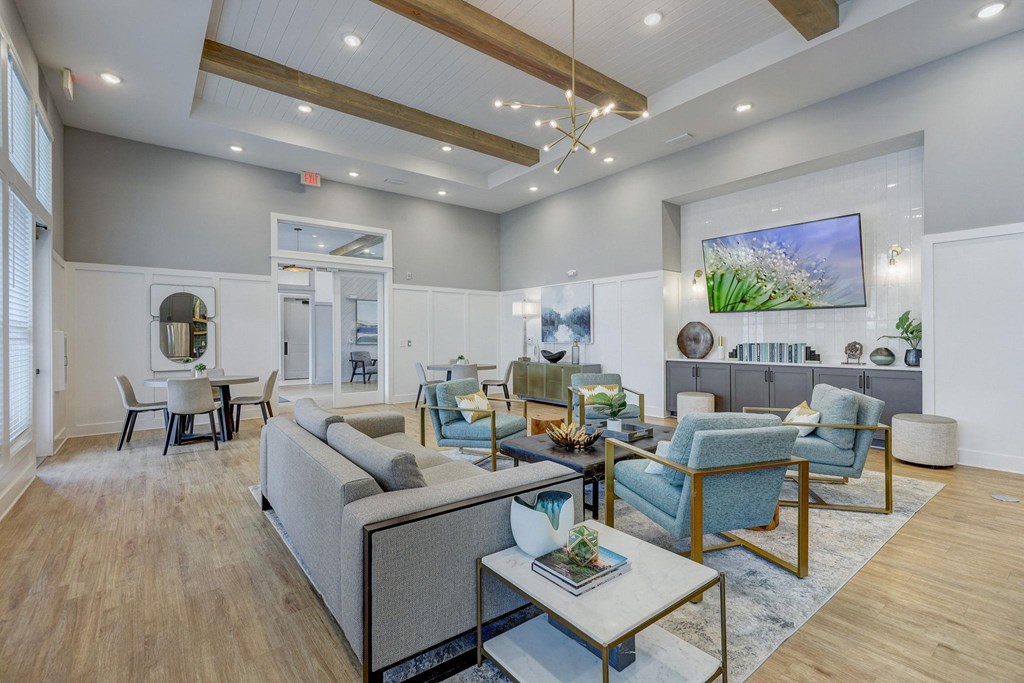 a living room with couches and chairs and a table at Century Mundy Mill Apartments, Oakwood, GA 30566