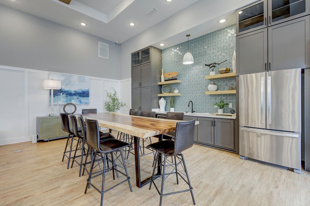 a kitchen with stainless steel appliances and a wooden table with chairs at Century Mundy Mill Apartments, Georgia