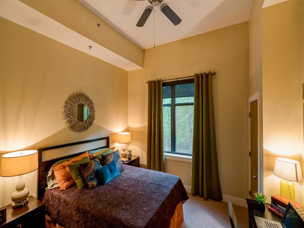 a bedroom with a bed and a ceiling fan