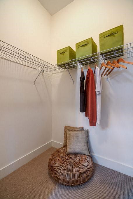 a room with a chair and a closet with clothes