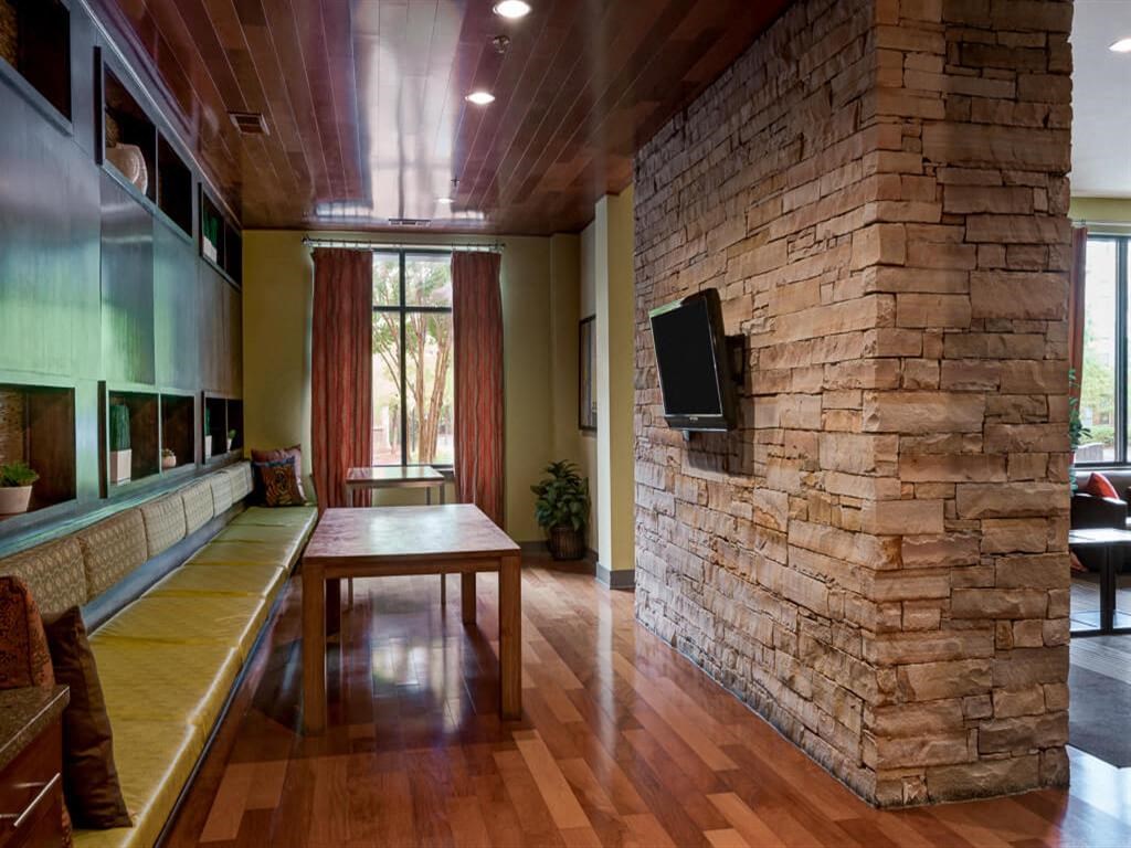 a living room with a stone wall and a table