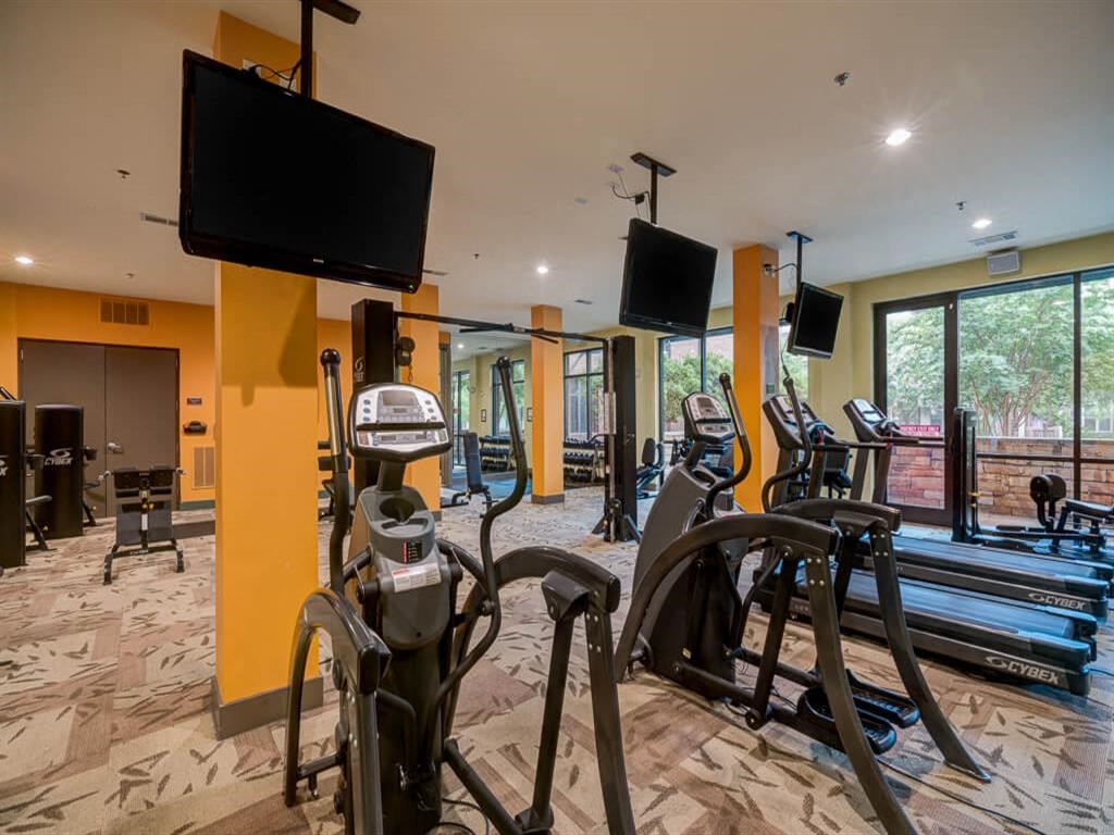 a gym with various exercise equipment and flat screen tv