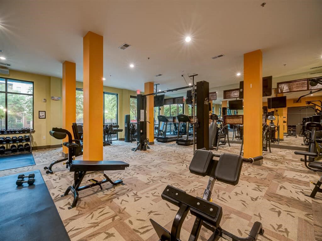 a gym with a lot of exercise equipment and a large window
