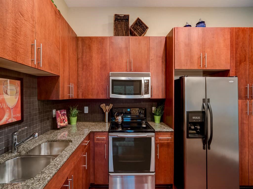 a kitchen with stainless steel appliances and wooden cabinets