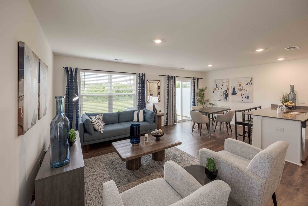 a living room with couches and chairs and a kitchen with a table