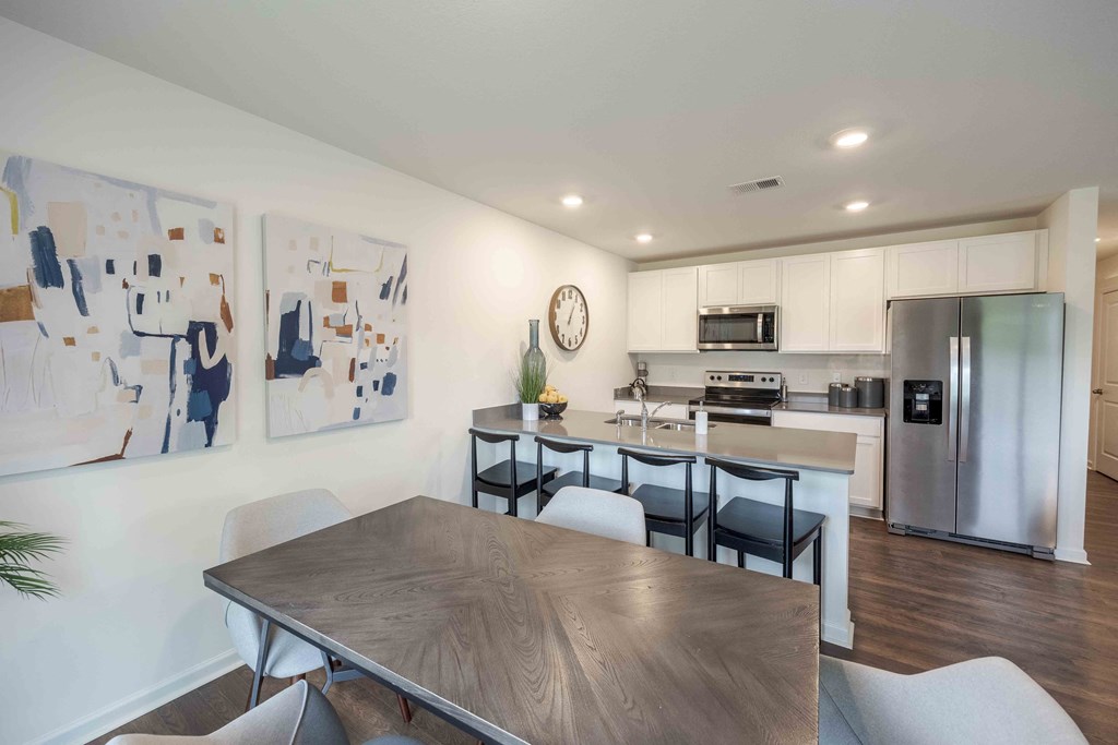 a kitchen and dining room with stainless steel appliances and a table