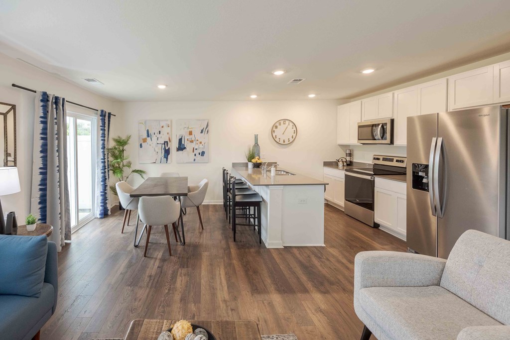 a kitchen and dining area with a stainless steel refrigerator