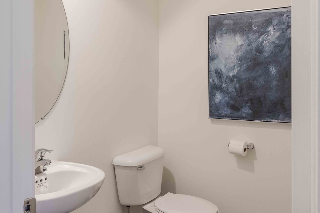 a white bathroom with a white toilet and a sink