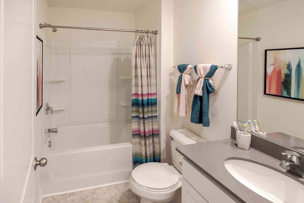 a bathroom with a shower and a sink and a toilet