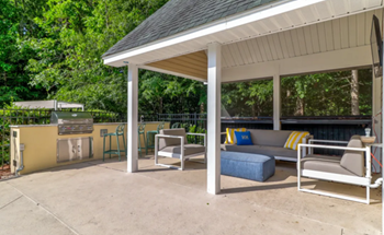 a covered patio with a grill and couches at Enclave at West Ashley Apartments, Charleston,32304