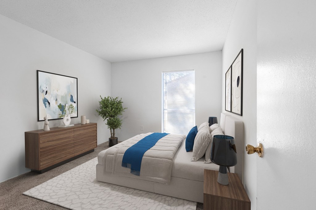 A bedroom with a bed, nightstand, and a plant. at Grove at St. Andrews, Columbia, SC